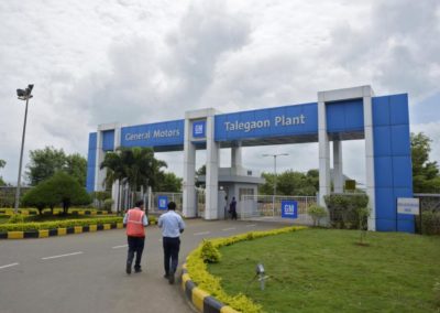 Employees walk to enter the General Motors plant in Talegaon on the outskirts of Pune